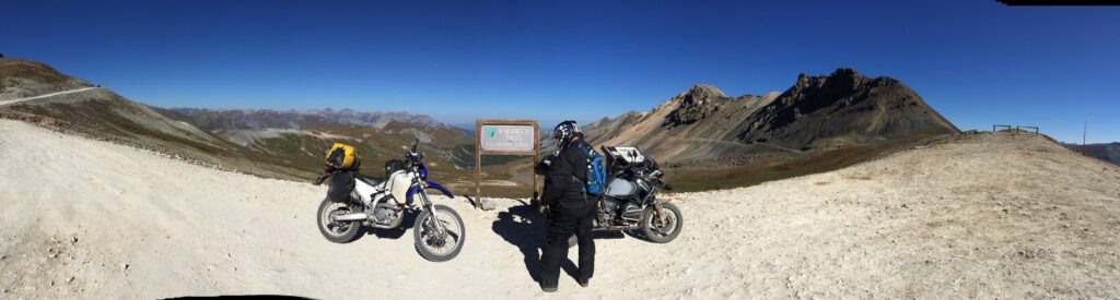 BMW 1200 GS adventure motorcycle and Yamaha WR250R dual sport motorcycle on top of a pass in the San Juan mountains Alpine Loop in southwestern Colorado
