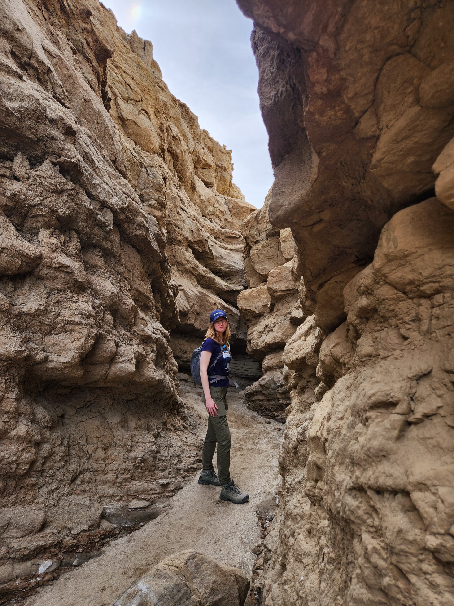 Woman stands in desert slot canyon