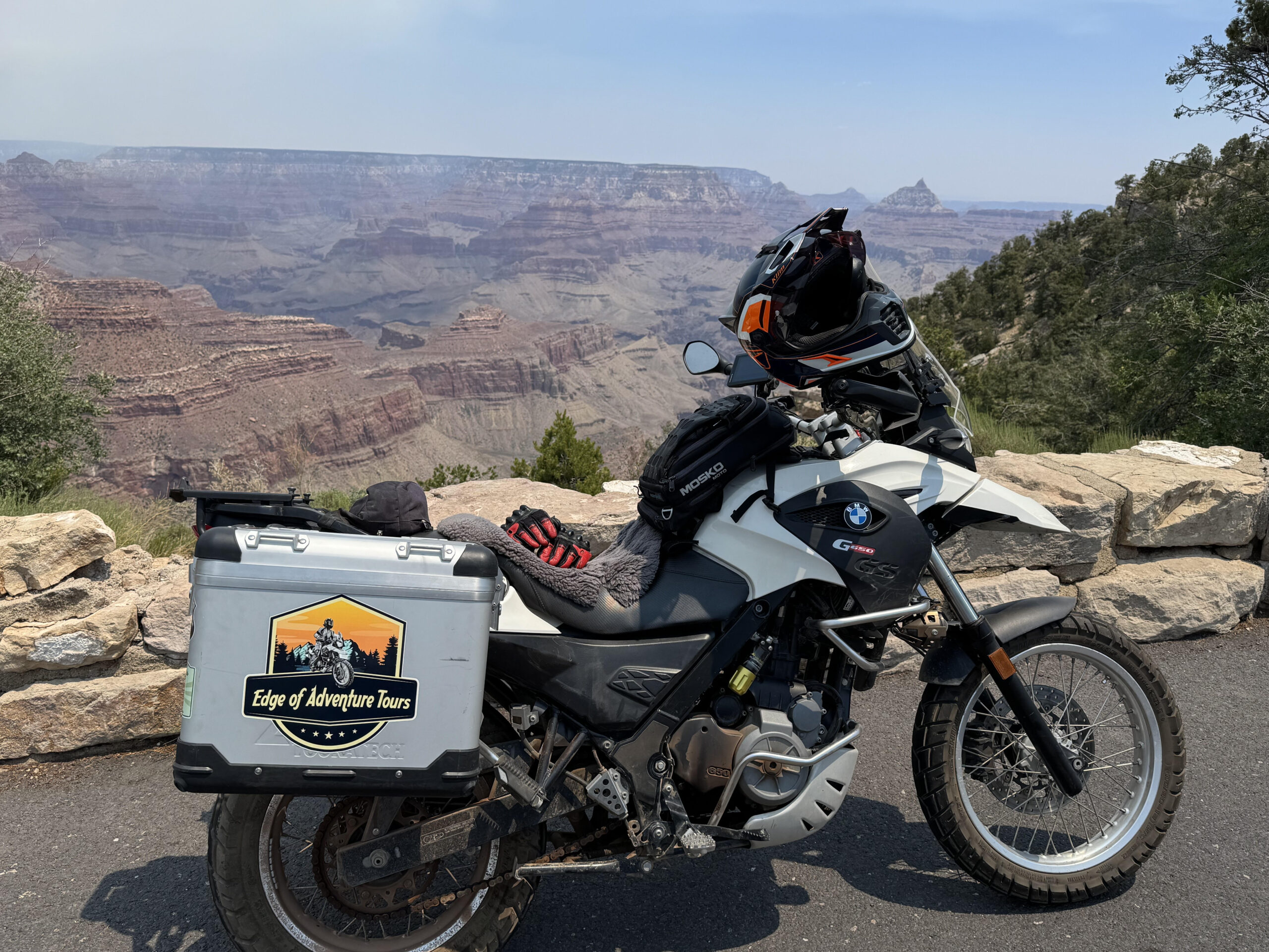 A white BMW G650GS motorcycle in front of the Grand Canyon