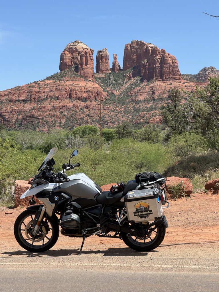 A BMW 1200GS adventure motorcycle in front of Sedona's red rock cliffs